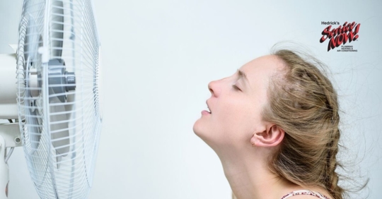 A woman sitting in front of a fan.