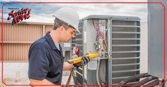 Man in hardhat providing maintenance to a HVAC unit.